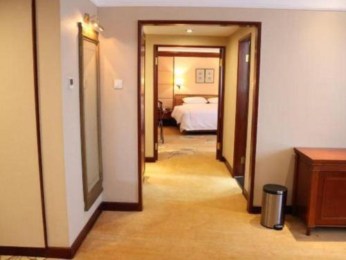 a hallway leading to a bedroom with a bed at Jianguo Garden Hotel in Beijing