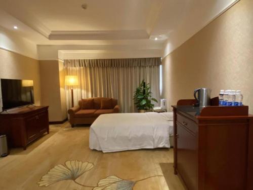 a hotel room with a bed and a couch at Jianguo Garden Hotel in Beijing