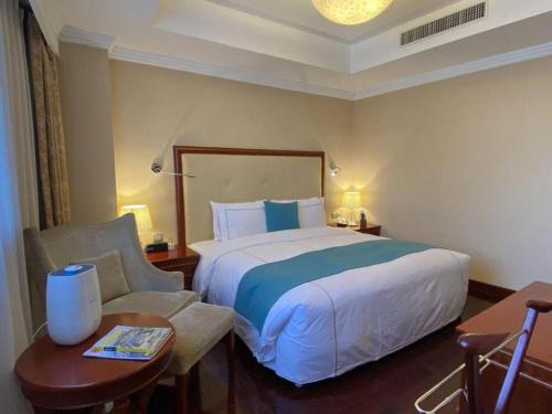 a hotel room with a bed and a chair at Jianguo Garden Hotel in Beijing