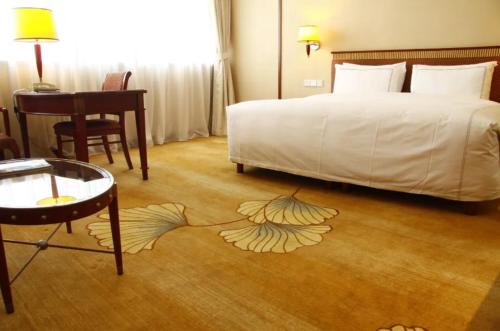 a bedroom with a bed with a leaf painted on the floor at Jianguo Garden Hotel in Beijing