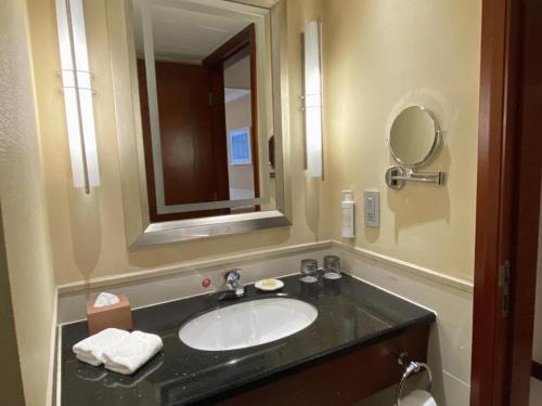a bathroom with a sink and a mirror at Jianguo Garden Hotel in Beijing