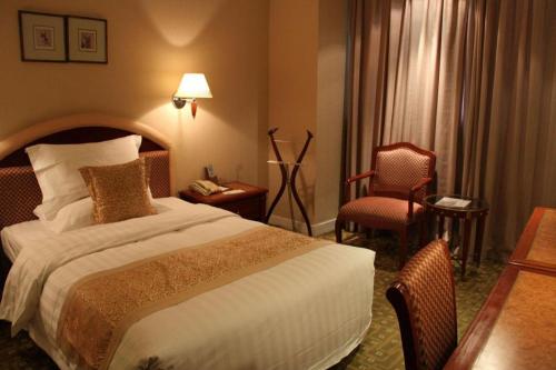 a hotel room with a bed and a table and chairs at Jianguo Garden Hotel in Beijing