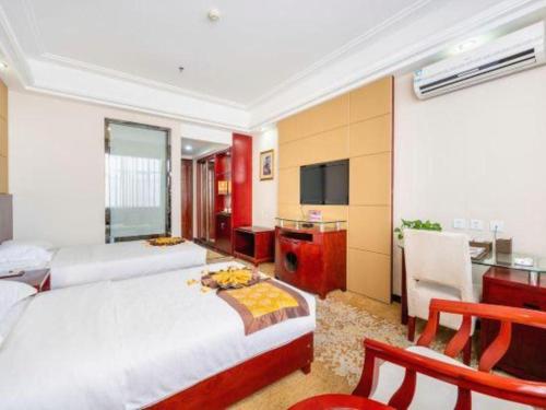 a bedroom with two beds and a kitchen with a sink at Tianrun International Hotel in Dunhuang
