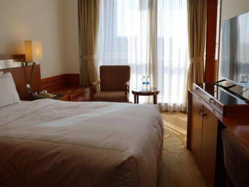 a hotel room with a bed and a television at Jianguo Garden Hotel in Beijing