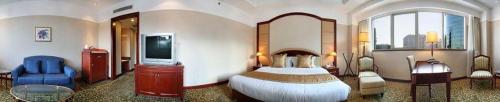 a bedroom with a large bed and a television at Jianguo Garden Hotel in Beijing