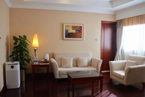 a living room with a couch and two chairs at Jianguo Garden Hotel in Beijing