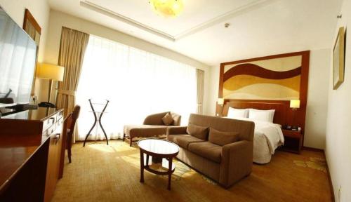 a hotel room with a couch and a bed at Jianguo Garden Hotel in Beijing
