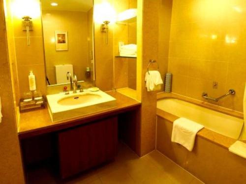 a bathroom with a sink and a bath tub at Jianguo Garden Hotel in Beijing