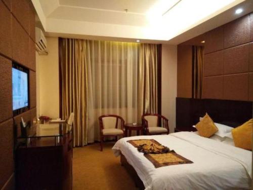 a hotel room with a bed and a desk and a television at Tianrun International Hotel in Dunhuang