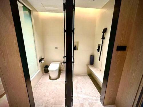 a bathroom with a toilet and a door in it at Tianrun International Hotel in Dunhuang