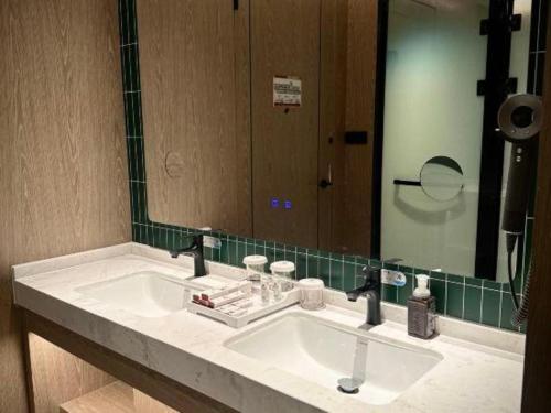 a bathroom with a sink and a large mirror at Tianrun International Hotel in Dunhuang