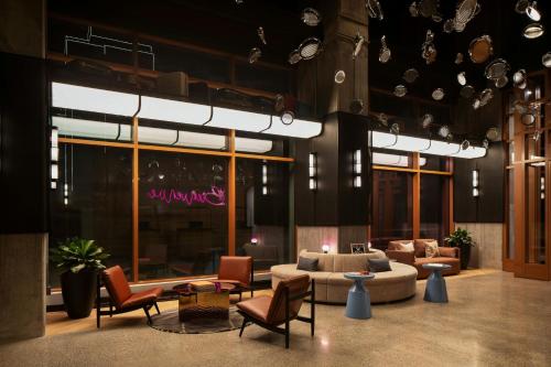 a living room with a couch and chairs at Moxy Montreal Downtown in Montréal