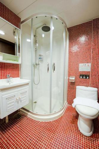 a bathroom with a shower and a toilet and a sink at Metroplace Olympic in Hong Kong