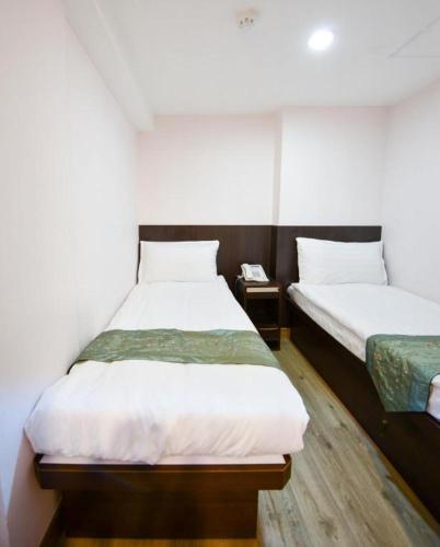 a room with two beds and a phone at Metroplace Olympic in Hong Kong