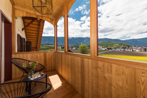 a balcony with a table and chairs and a window at Niedermairhof in Brunico