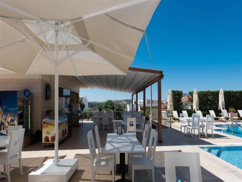 a patio with a table and chairs and a pool at Kamer Exclusive Hotel & Suites in Çeşme