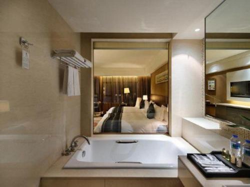 a bathroom with a bath tub and a bedroom at Putian Depo Hotel in Putian