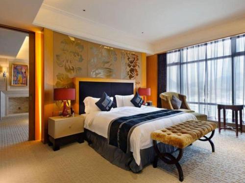 a bedroom with a large bed and a large window at Putian Depo Hotel in Putian
