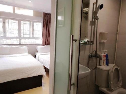 a hotel room with a bathroom with a bed and a sink at New Star Guest House in Hong Kong