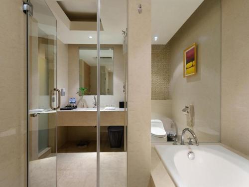 a bathroom with a tub and a toilet and a sink at Putian Depo Hotel in Putian