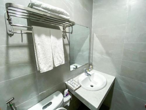 a white bathroom with a sink and a mirror at Duong Chau Hotel in Bùi Tiếng