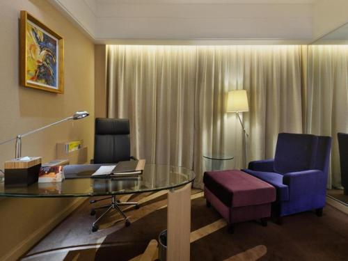 a hotel room with a table and a purple chair at Putian Depo Hotel in Putian
