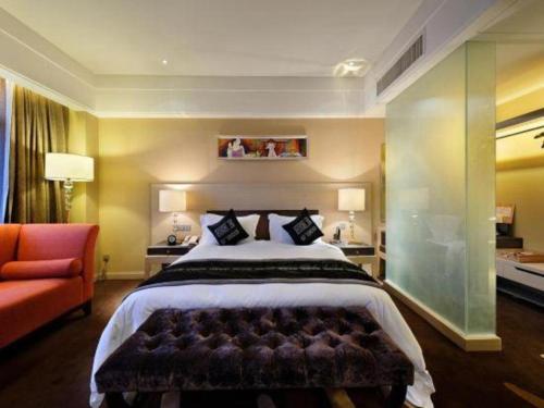 a bedroom with a large bed and a red couch at Putian Depo Hotel in Putian