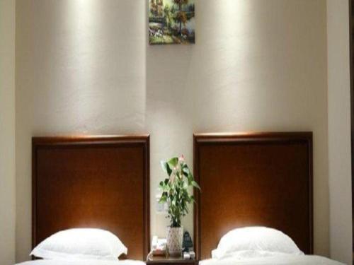two beds with wooden headboards in a bedroom at GreenTree Inn Anhui Bozhou West Guangming Road Tangwang Avenue Shall Hotel in Bozhou