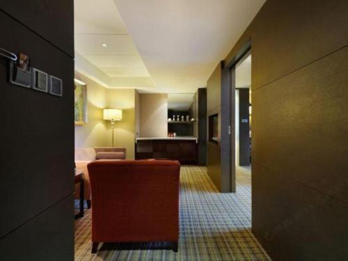 a hotel room with a chair and a living room at Putian Depo Hotel in Putian