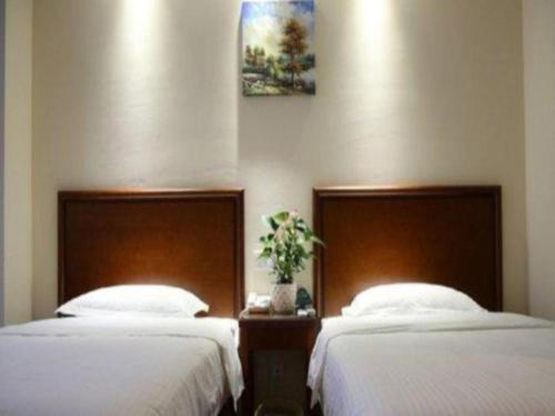two beds sitting next to each other in a room at GreenTree Inn Anhui Bozhou West Guangming Road Tangwang Avenue Shall Hotel in Bozhou