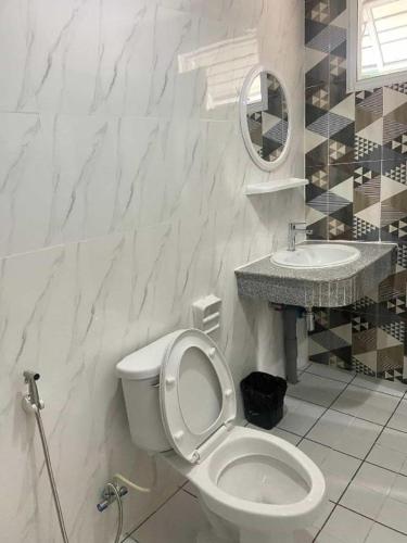 a white bathroom with a toilet and a sink at Hihotel Saraburi in Sara Buri