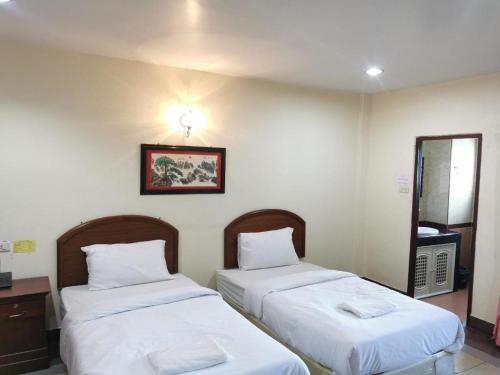 two beds in a room with white sheets at Hihotel Saraburi in Sara Buri
