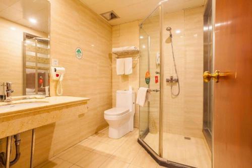 a bathroom with a toilet and a glass shower at GreenTree Inn Kunshan Shimao Plaza Business Hotel in Suzhou