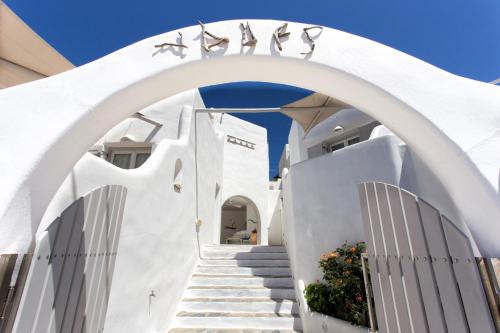 a white building with stairs under an arch at Yades Suites & Spa - Adults only in Naousa