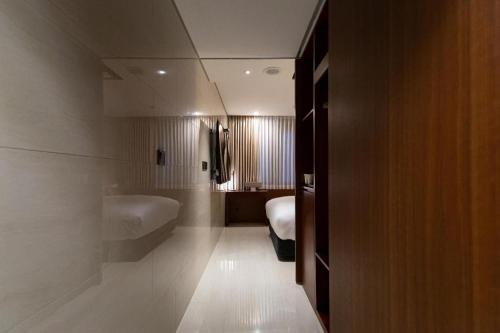 a bathroom with a tub and a bed and a sink at Top Cloud Hotel Iksan in Iksan