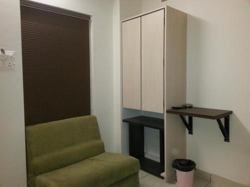 a living room with a green chair and a table at Hotel Pisals in Bhopal