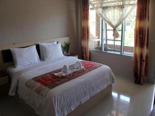 a bedroom with a large bed with a window at Samosir Cottages Resort in Tuk Tuk