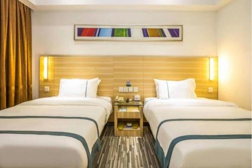 a hotel room with two beds and a window at City Comfort Inn Zhaoqing Qixingyan Scenic Area Xinghu Archway in Zhaoqing