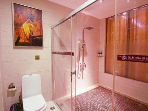 a bathroom with a glass shower with a toilet at Shenzhen Kai Long International Hotel in Shenzhen