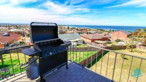 a stove on a balcony with a view of the ocean at Waves at Caves in Caves Beach