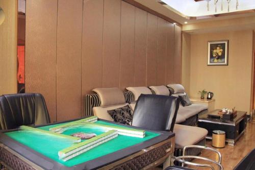 a ping pong table in a room with chairs at Shenzhen Kai Long International Hotel in Shenzhen