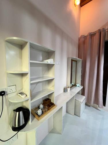 a kitchen with white shelves and a sink at Home In Dhigurah in Dhigurah