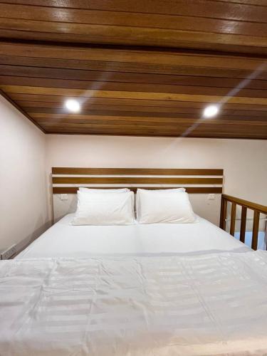a bedroom with a white bed with two pillows at Home In Dhigurah in Dhigurah