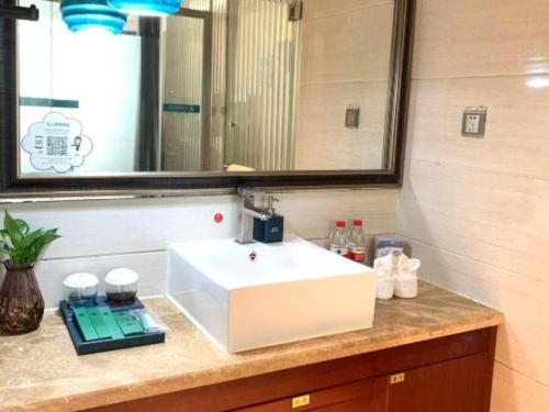 a bathroom counter with a sink and a mirror at Shenzhen Kai Long International Hotel in Shenzhen