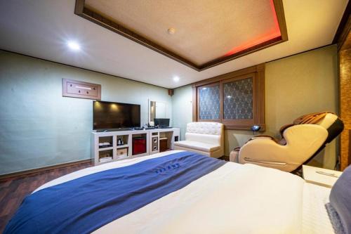 a bedroom with a large bed and a television at SKY Hotel in Changwon
