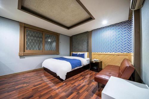 a bedroom with a bed and a couch in it at SKY Hotel in Changwon