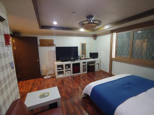 a bedroom with a bed and a flat screen tv at SKY Hotel in Changwon