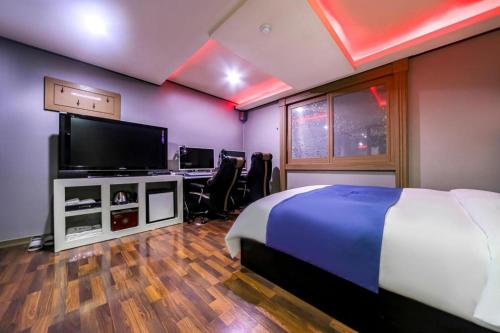a bedroom with a bed and a flat screen tv at SKY Hotel in Changwon