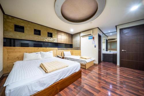 a bedroom with a large bed and a bathroom at SKY Hotel in Changwon