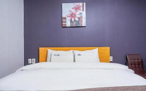 a bedroom with a large bed with white sheets at Luxury Motel Daejeon in Daejeon